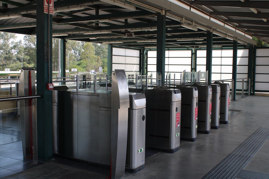 A pair of metal bar barriers with white panels displaying red 'no entry' symbols are positioned across a doorway of a house, blocking access to the outdoor area which is visible behind the gates. The 